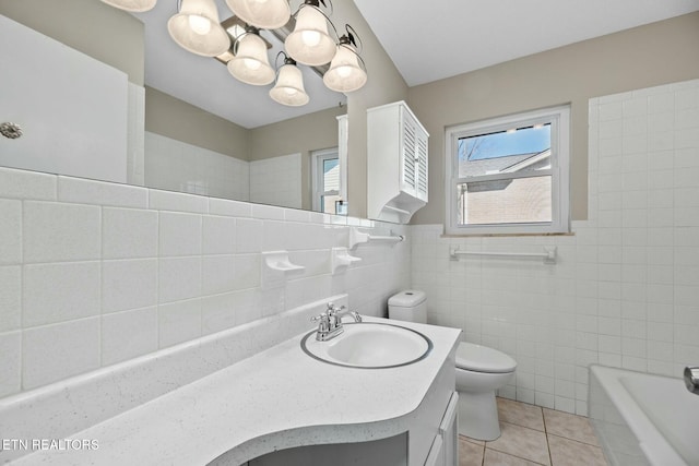 bathroom featuring tile patterned flooring, vanity, toilet, and tile walls