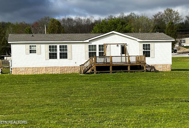 rear view of property with a yard and a wooden deck