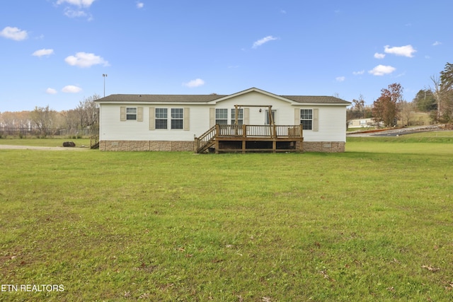 view of front facade featuring a wooden deck and a front yard