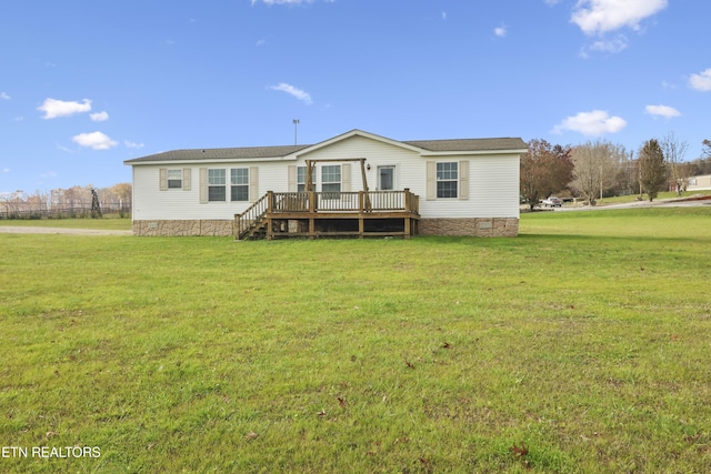 back of house featuring a lawn and a wooden deck