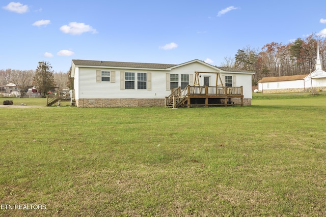 back of house featuring a lawn and a wooden deck