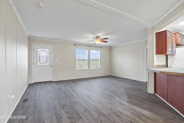 unfurnished living room featuring ceiling fan, dark hardwood / wood-style flooring, and crown molding