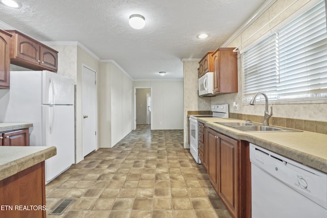 kitchen featuring a textured ceiling, white appliances, ornamental molding, and sink