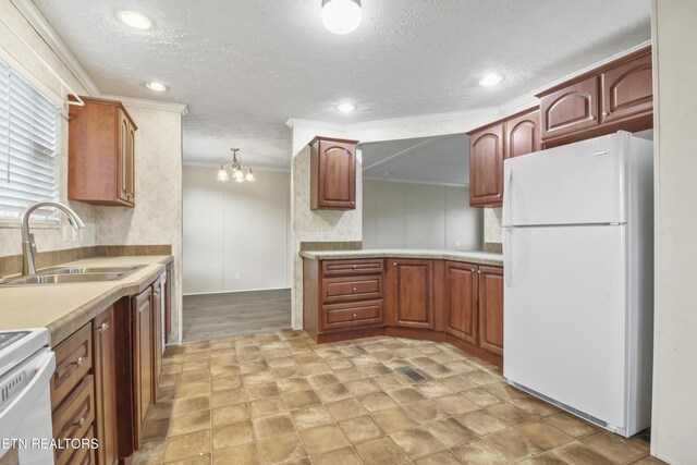 kitchen with white appliances, an inviting chandelier, sink, crown molding, and decorative light fixtures