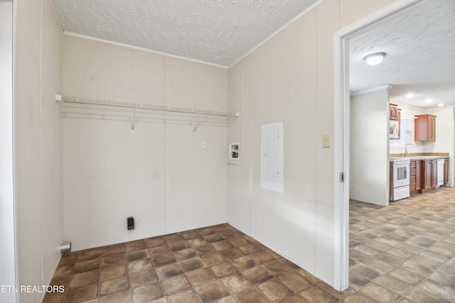 washroom with electric panel, sink, crown molding, washer hookup, and a textured ceiling