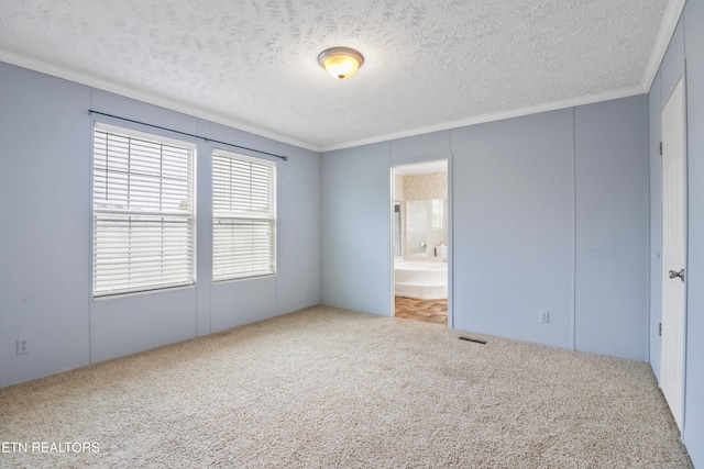 unfurnished bedroom featuring ensuite bathroom, crown molding, carpet floors, and a textured ceiling