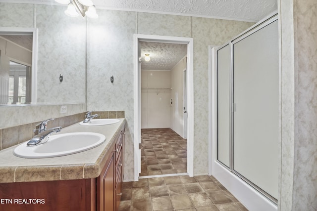 bathroom featuring vanity, a textured ceiling, and walk in shower