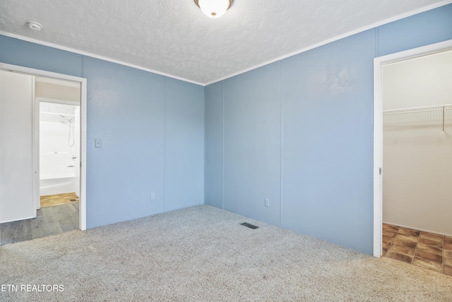 unfurnished bedroom with a closet, carpet, and a textured ceiling