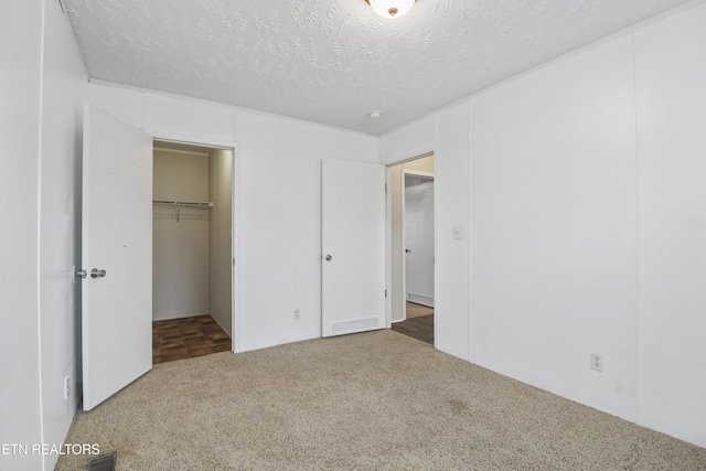 unfurnished bedroom featuring carpet, a textured ceiling, and a closet