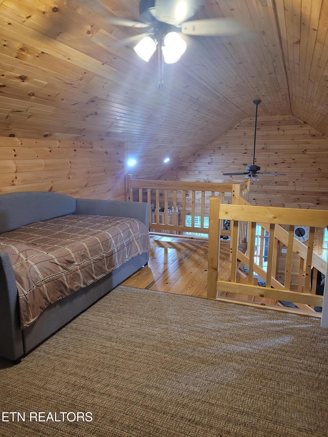 unfurnished bedroom featuring vaulted ceiling, hardwood / wood-style floors, wooden ceiling, and wooden walls