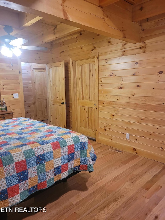 bedroom with wood-type flooring and wood walls