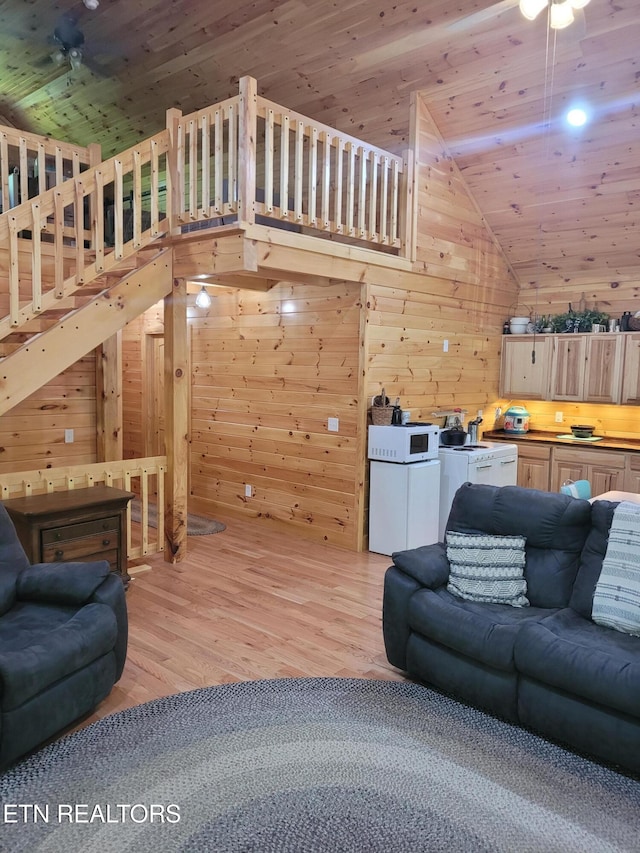 living room featuring high vaulted ceiling, wooden walls, wooden ceiling, and light hardwood / wood-style floors