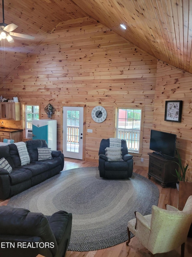 living room with hardwood / wood-style floors, wood ceiling, wooden walls, and high vaulted ceiling