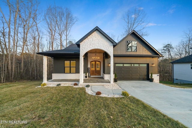 view of front of property with covered porch, a garage, and a front yard