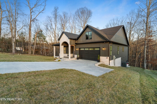 view of front facade with a front yard, a garage, and central AC unit