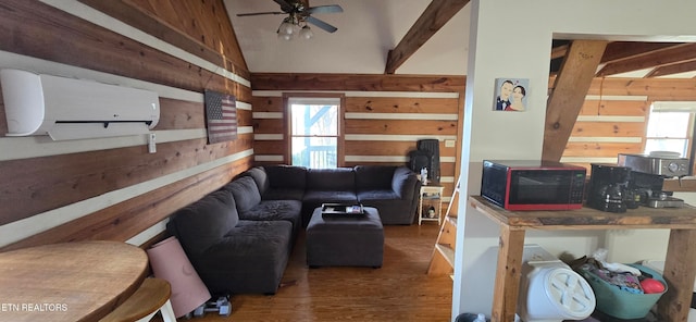 living room with lofted ceiling, a healthy amount of sunlight, a wall mounted air conditioner, and wood-type flooring