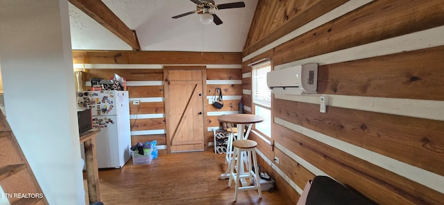 interior space with dark wood-type flooring, an AC wall unit, ceiling fan, and lofted ceiling