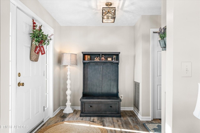 foyer entrance with dark hardwood / wood-style flooring and a textured ceiling