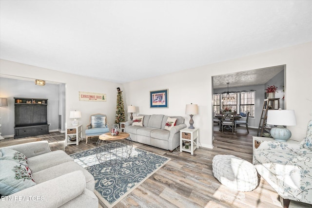 living room with wood-type flooring and an inviting chandelier