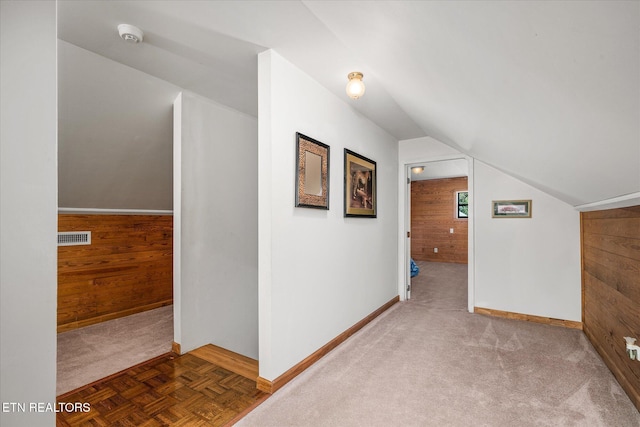 bonus room featuring wood walls, lofted ceiling, and parquet flooring