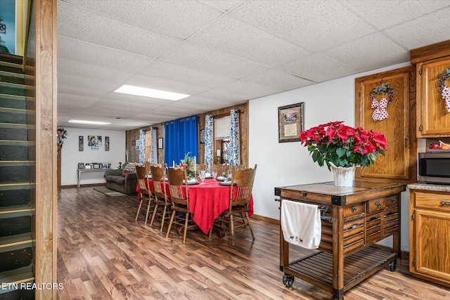 dining area with hardwood / wood-style floors and a drop ceiling