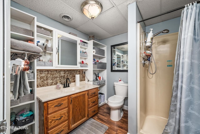 bathroom featuring a shower with curtain, hardwood / wood-style floors, a paneled ceiling, decorative backsplash, and vanity