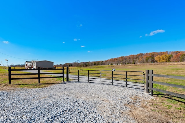 view of gate featuring a rural view and a yard