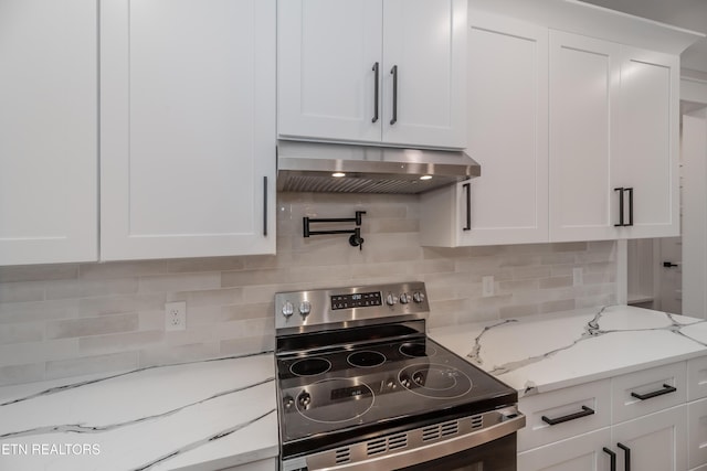 kitchen featuring extractor fan, light stone countertops, stainless steel electric range oven, decorative backsplash, and white cabinets