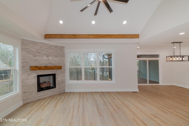 unfurnished living room with a stone fireplace, wood finished floors, and baseboards