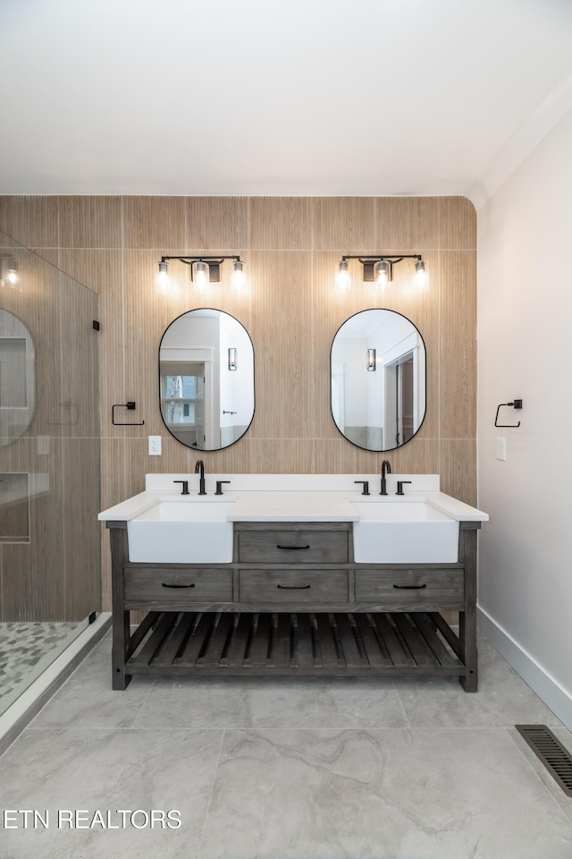 full bath featuring visible vents, a stall shower, a sink, and double vanity