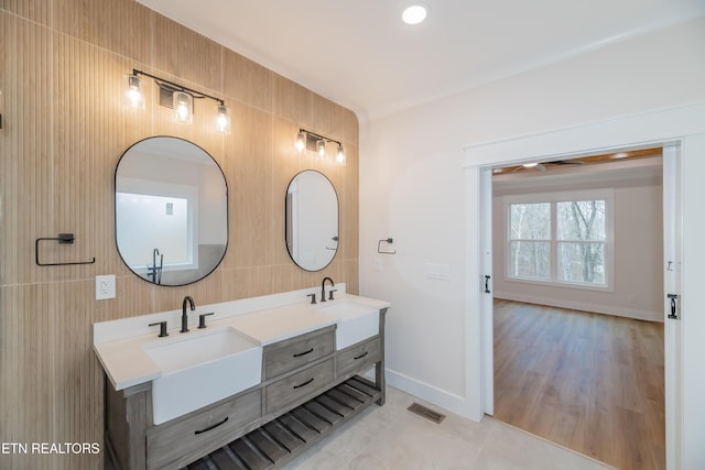 bathroom featuring double vanity, baseboards, visible vents, and a sink