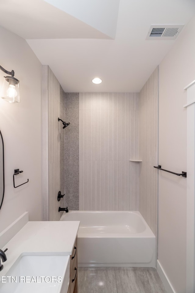 full bathroom featuring visible vents, vanity, wood finished floors, and shower / bathtub combination