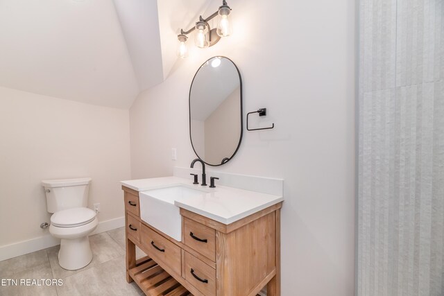 full bath featuring vanity, baseboards, lofted ceiling, tile patterned floors, and toilet