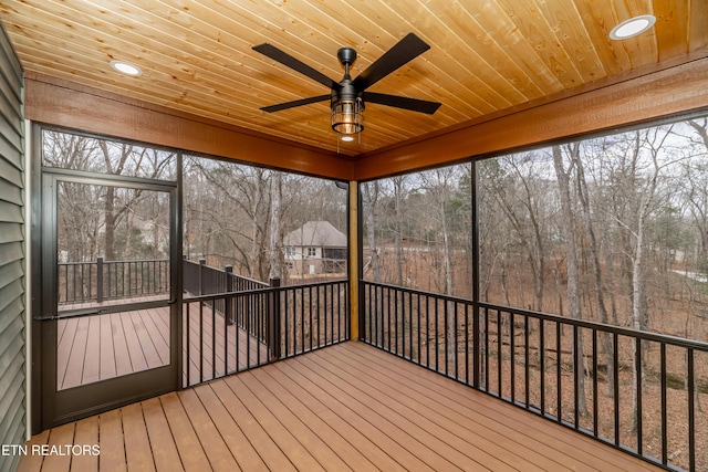 unfurnished sunroom featuring a healthy amount of sunlight, wood ceiling, and a ceiling fan