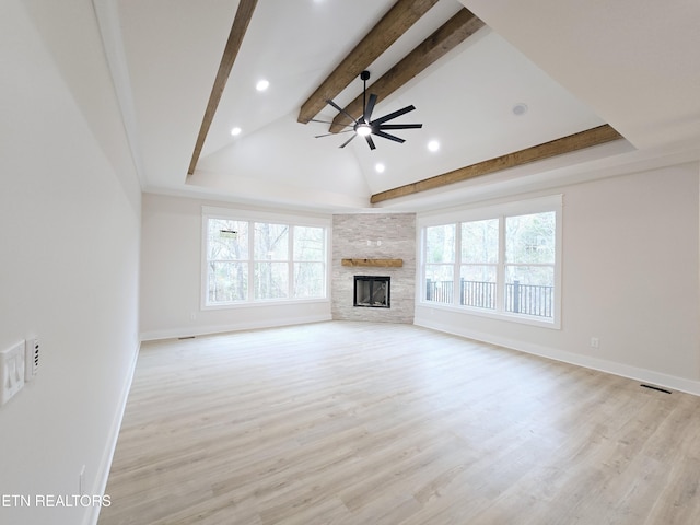 unfurnished living room with a fireplace, vaulted ceiling with beams, light wood-style floors, and a ceiling fan