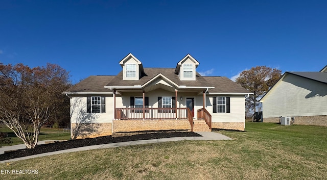 cape cod home with central AC, covered porch, and a front yard