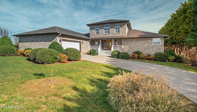 view of front of property with covered porch, a garage, and a front yard