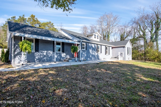 view of front of home with a patio and a front yard