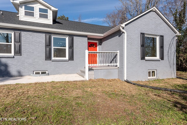 view of front of home with a patio and a front lawn