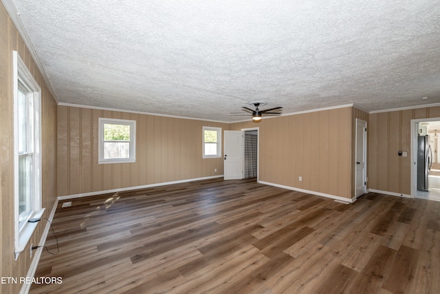 unfurnished living room with ceiling fan, crown molding, and dark hardwood / wood-style floors