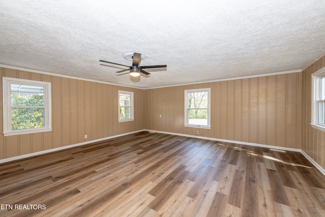 empty room featuring wood-type flooring, ceiling fan, and crown molding