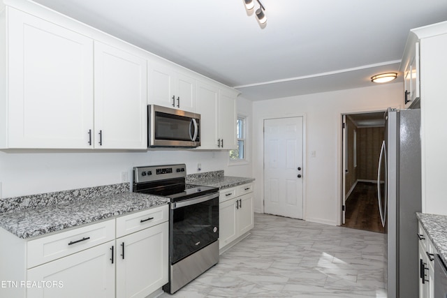 kitchen featuring light stone counters, white cabinetry, and appliances with stainless steel finishes