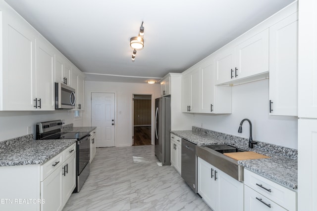 kitchen with light stone countertops, white cabinets, and appliances with stainless steel finishes