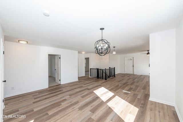 unfurnished living room featuring light hardwood / wood-style flooring and a notable chandelier