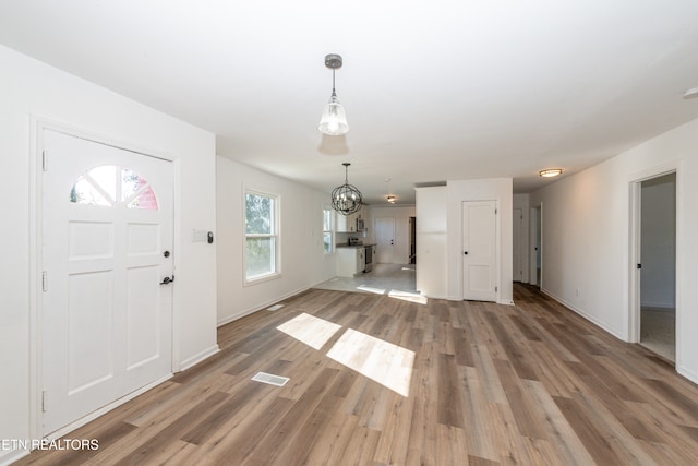 entryway featuring hardwood / wood-style floors and a chandelier