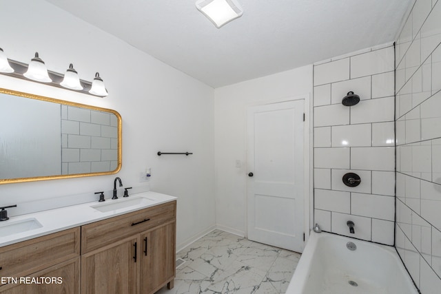 bathroom featuring tiled shower / bath and vanity