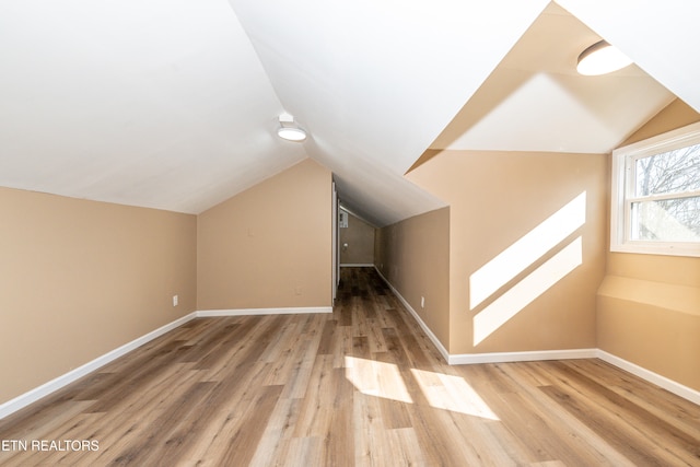 bonus room with vaulted ceiling and wood-type flooring