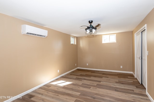 basement with hardwood / wood-style flooring and a wall unit AC