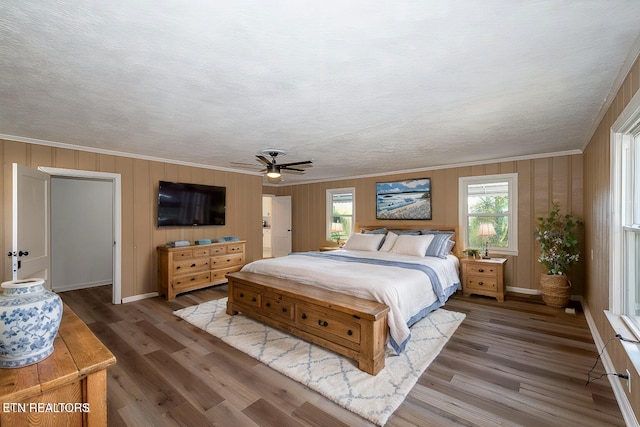 bedroom with ceiling fan, wood-type flooring, and ornamental molding