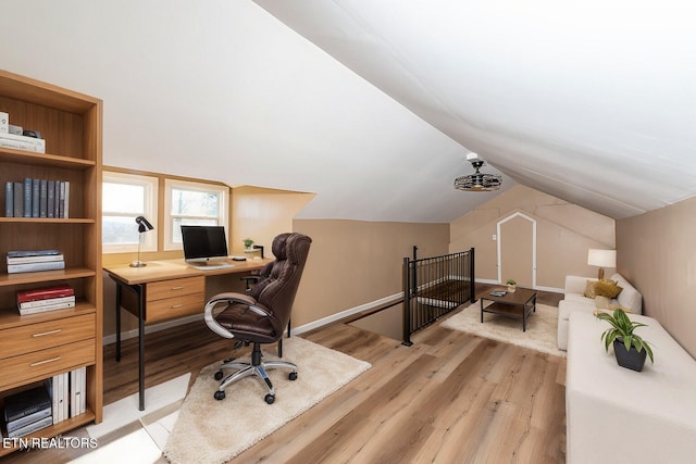 office space featuring vaulted ceiling and light hardwood / wood-style floors